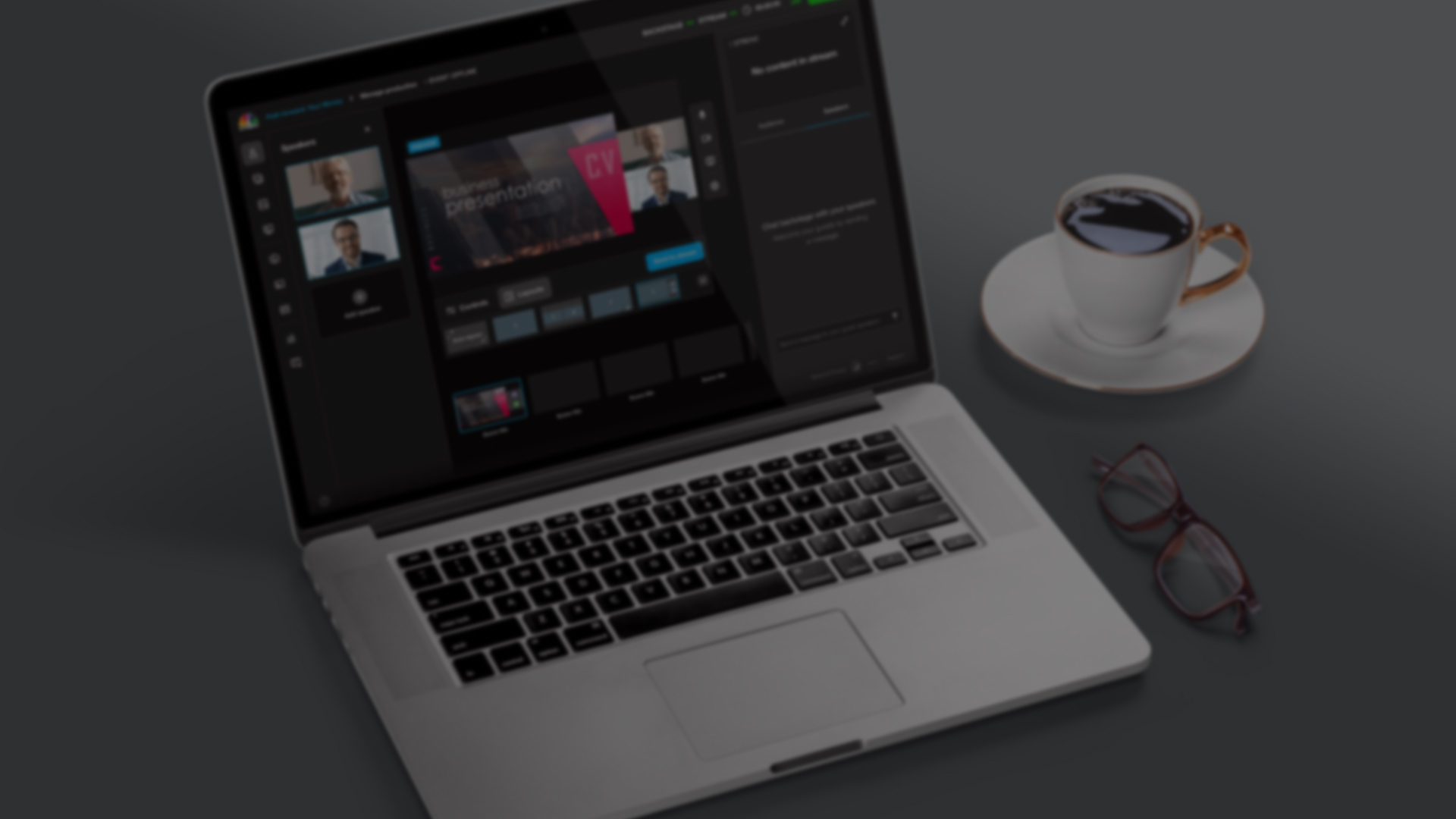 A webinar management platform interface is displayed on a laptop screen. Speaker live feeds are on the left, presentation slides on the right, and the webinar title at the top. Interactive tools for audience questions and polls are at the bottom. A coffee cup and glasses rest beside the laptop.
